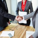 Successful business partners handshaking after signing contract